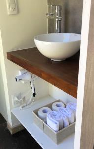 a bathroom with a sink and a bunch of towels at Aromos Lodge- Chacras de Coria- in Ciudad Lujan de Cuyo