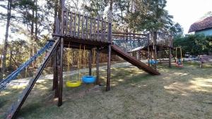 un parque infantil de madera con un tobogán en un patio en Chalé dos Pássaros - Varanda com vista p/ Natureza, en Campos do Jordão