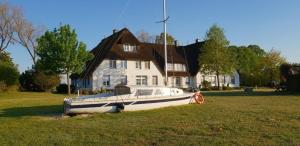Stolpe auf UsedomにあるLandhaus am Haff - Wohnung B1の家の前の芝生に座る舟