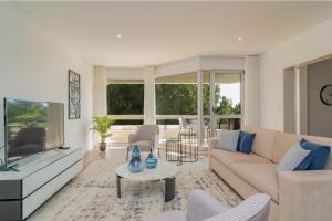 a living room with a couch and a tv at Coastal Charm by LovelyStay in Oeiras