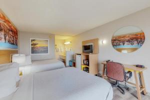 1 dormitorio con 2 camas, escritorio y espejo en Days Inn by Wyndham Socorro, en Socorro