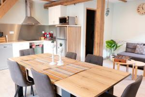 eine Küche und ein Esszimmer mit einem Holztisch und Stühlen in der Unterkunft Les Granges De Jadis d'Alsace in Holtzwihr
