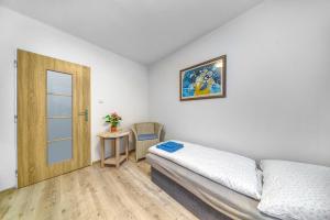 a bedroom with a bed and a door and a table at Apartmány Kašper in Levoča