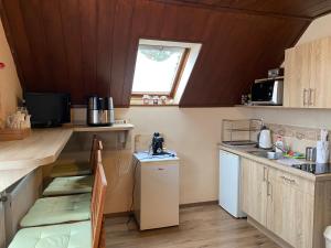 a small kitchen with wooden walls and a window at Belle-Aire Vendégház Mátraszentlászló in Mátraszentimre