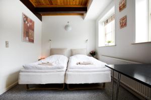 two beds in a room with white walls at Motel Stege in Stege