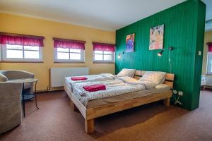 a bedroom with a bed with a green wall at Penzion Slunečnice in Rokytnice nad Jizerou