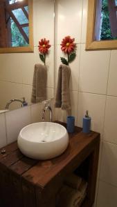 y baño con lavabo blanco sobre una mesa de madera. en Chalé dos Tucanos- Parede de vidro com linda vista, en Campos do Jordão