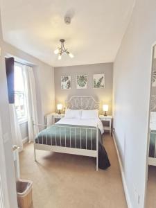 een slaapkamer met een bed en twee tafels en twee lampen bij The Elleray in Windermere