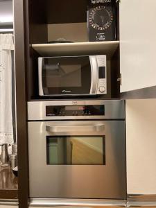 A cozinha está equipada com um micro-ondas e um forno. em Thesan Lodge, chic & modern design apartment em Grosseto