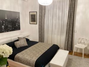 a bedroom with a bed and a chandelier at Thesan Lodge, chic & modern design apartment in Grosseto