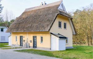 een oud huis met een rieten dak en een garage bij Reetdachhaus 27 Auf Usedom in Kutzow