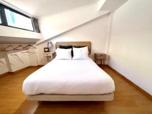 um quarto com uma grande cama branca num sótão em Central Gem I- Apartment in Trendy Neighborhood em Lisboa