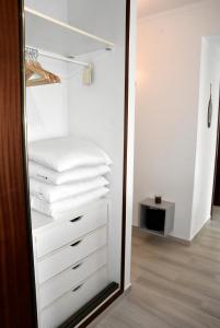 a closet with white towels and a mirror at Casa Azul in Monte Gordo