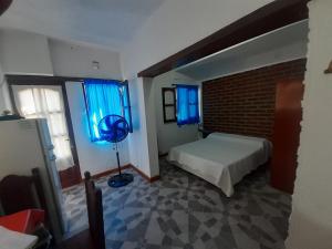 a bedroom with a bed and a blue window at Alojamiento Los Amigos in Vaqueros