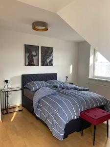 a bedroom with a bed and a red stool at Haus Lisa in Neustadt in Holstein