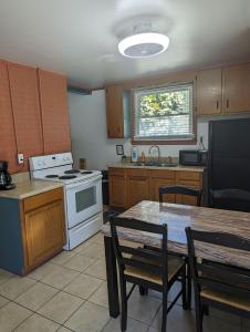 a kitchen with a stove and a table with chairs at Anvil Campground in Williamsburg