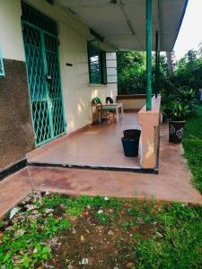 a porch of a house with a table and chairs at Home from home in Mbale