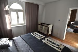 Apartmán Terezka في ماريانسكي لازني: غرفة نوم بسرير وسرير أطفال ونافذة