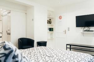 a bedroom with a bed and a desk and a television at Kimia House in Osny