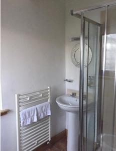 a white bathroom with a sink and a shower at Island View House in Ullapool