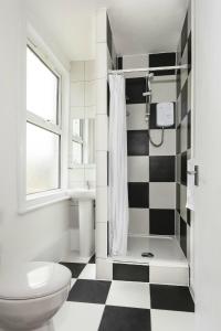 a bathroom with a black and white checkered floor at The Station Hotel in Norwich