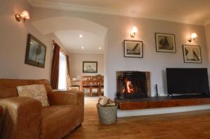 a living room with a couch and a fireplace at Cologin Farmhouse in Oban