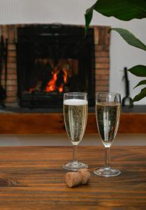 two glasses of champagne on a table with a fireplace at Cologin Farmhouse in Oban