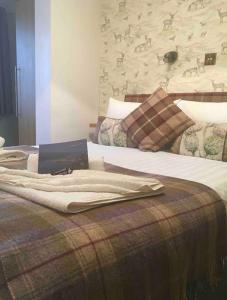 a bed with a blanket on top of it at Island View House in Ullapool