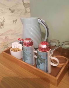 a wooden tray with three mugs and a pitcher at Island View House in Ullapool