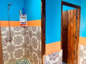 baño con espejo y pared de azulejos en Desert Backpackers hostel, en Merzouga