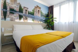 - une chambre avec un grand lit et une couverture jaune dans l'établissement Hotel BESTPRICE Alcalá, à Madrid