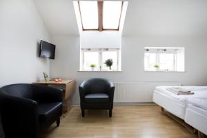 a bedroom with a bed and a chair and windows at Motel Stege in Stege