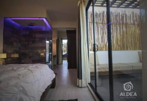 ein Schlafzimmer mit einem Bett und einem lila Licht in der Unterkunft SUITE CON JACUZZI Y TERRAZA PRIVADOS EN PIRAMIDES in San Martín de las Pirámides