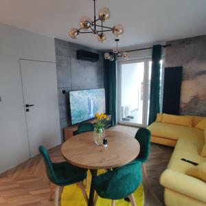 uma sala de jantar com uma mesa e cadeiras e um sofá em Apartament Perła Kutna em Kutno