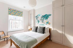 a white bedroom with a bed and a window at Lovely Camberwell House in London