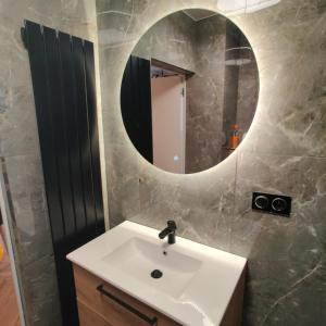 a bathroom with a white sink and a mirror at Apartament Perła Kutna in Kutno
