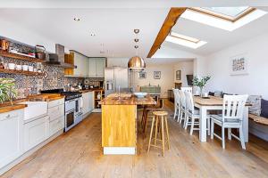a kitchen with white cabinets and a wooden table at Lovely Camberwell House in London