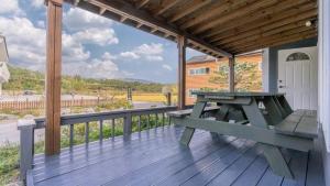 eine Holzterrasse mit einem Picknicktisch auf einem Haus in der Unterkunft Tinkerbell detached house in Gyeongju