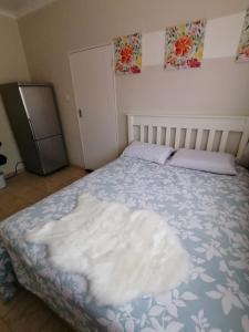 Una cama con una manta blanca en un dormitorio en Country Block, en Gaborone