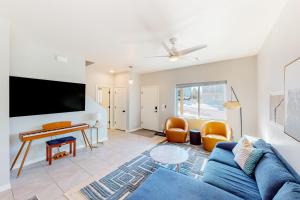 a living room with a blue couch and a flat screen tv at The Pine House in Flagstaff