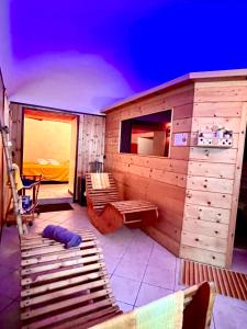 a room with a sauna with benches and a bed at Dormi nella SPA privata con letto ad acqua, sauna, doccia emozionale e kneipp in Alessandria