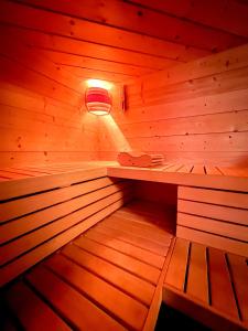 a wooden sauna with a light in the middle at Dormi nella SPA privata con letto ad acqua, sauna, doccia emozionale e kneipp in Alessandria