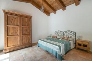 1 dormitorio con 1 cama y armario de madera en Piano del Mulino, en Orvieto