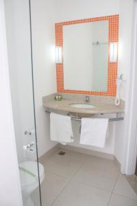 a bathroom with a sink and a mirror at Hotel e Pousada Bem Bom - Itu in Itu