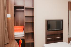 a room with a closet with a tv and a bed at Hotel e Pousada Bem Bom - Itu in Itu