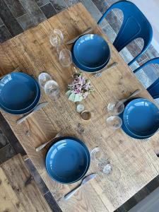 a table with blue plates and wine glasses on it at Modern country house near Fontainebleau in Samoreau +12 photos