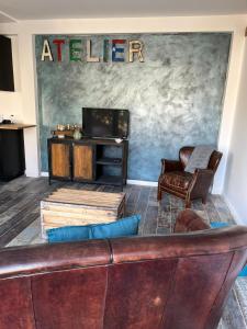 a waiting room with a couch and a television at Modern country house near Fontainebleau in Samoreau