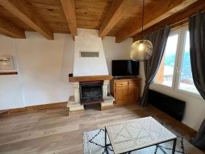 a living room with a fireplace and a tv at Appart Duplex Chalet plein Sud in Feissons-sur-Salins