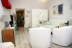 een woonkamer met witte meubels en witte krukken bij QuickHome La Ninfea in Viverone