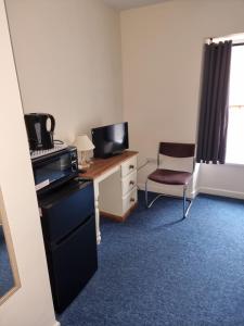 Zimmer mit einem Schreibtisch, einem Computer und einem Stuhl in der Unterkunft Kings Arms Hotel Ebbw Vale in Ebbw Vale